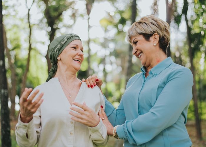 Paciente haciendo yoga suave con frutas frescas y adaptógenos para favorecer la armonía inmunitaria y hormonal durante la inmunoterapia contra el cáncer de cuello de útero.